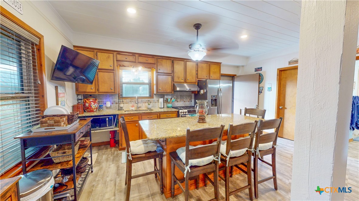 509 Monroe Avenue Port O'Connor, TX 77982 - Photo 35 of 46 a dining hall with stainless steel appliances a dining table and chairs with wooden floor