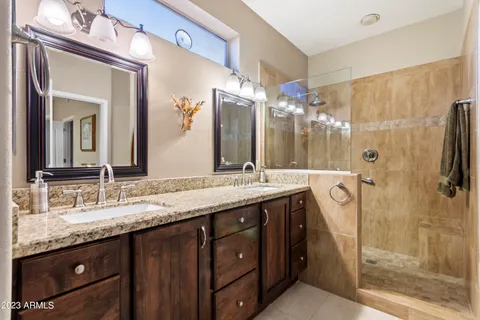 a bathroom with a granite countertop sink shower and a mirror