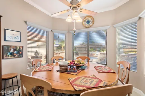 a view of a dining room with furniture a chandelier and a large window