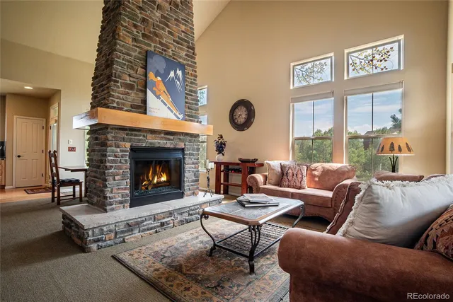 a living room with furniture a large window and a fireplace