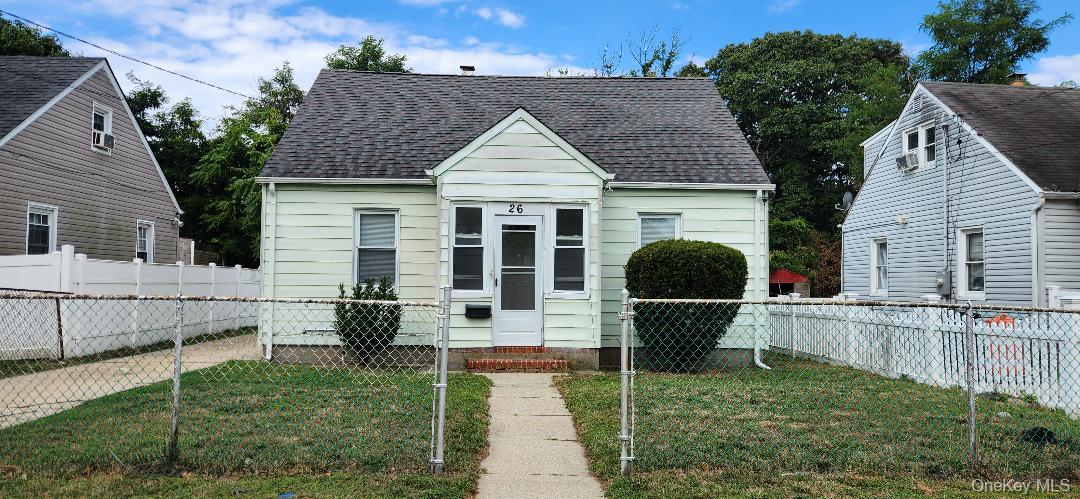 View of front of house featuring a fenced front yard, roof with shingles, and a gate
