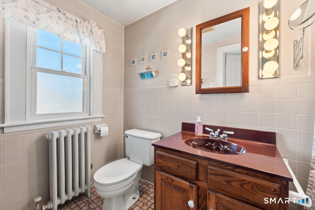 75 Elizabeth Terrace Stratford, CT 06614 - Photo 27 of 38 a bathroom with a sink a toilet and a mirror
