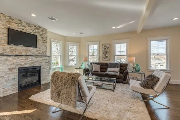 a living room with furniture a flat screen tv and a fireplace
