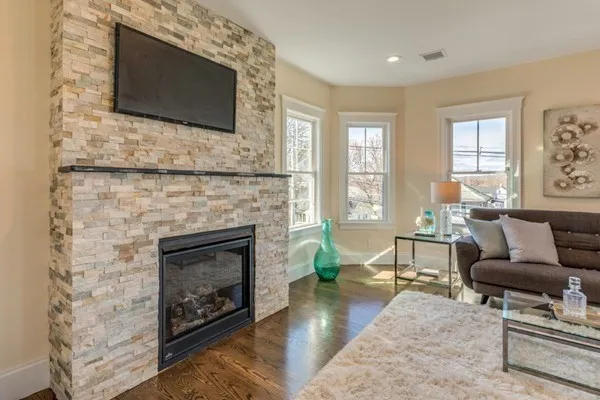 a living room with furniture a flat screen tv and a fireplace