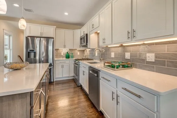 a kitchen with a sink a counter top space stainless steel appliances and cabinets