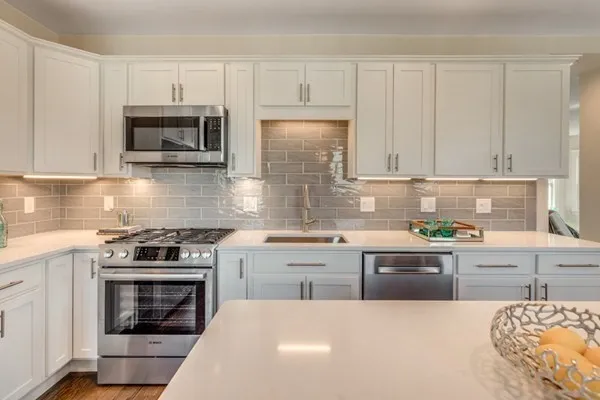 a kitchen with cabinets appliances and a window