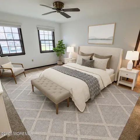 a spacious bedroom with a bed a couch and windows