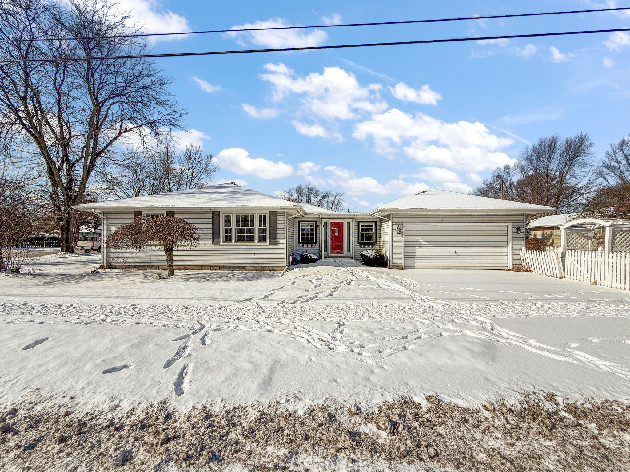 a front view of a house with a yard covered in snow