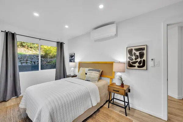 a bedroom with a bed and a large window