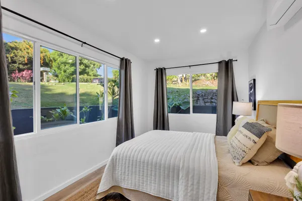 a bedroom with a large window and a bed