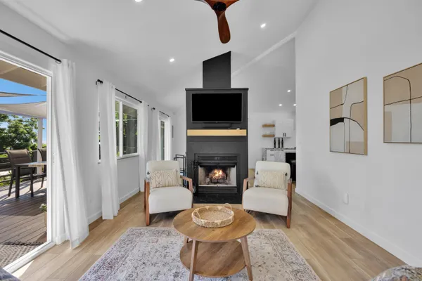 a living room with furniture a flat screen tv and a fireplace