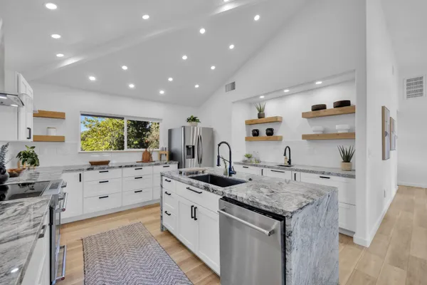 a large kitchen with stainless steel appliances granite countertop a sink and a stove
