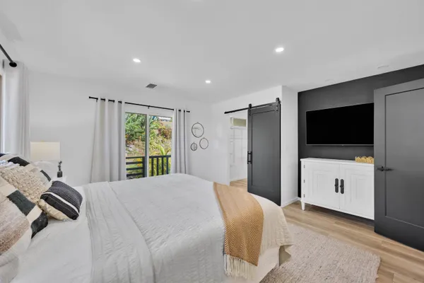 a bedroom with a bed and a flat screen tv