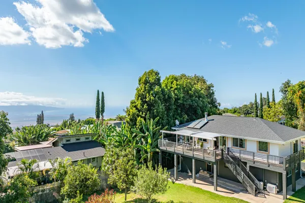 a aerial view of a house with swimming pool and large trees