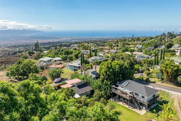 an aerial view of a house with a yard and lake view
