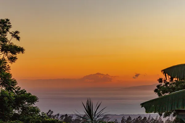 a view of an ocean with a mountain in the background