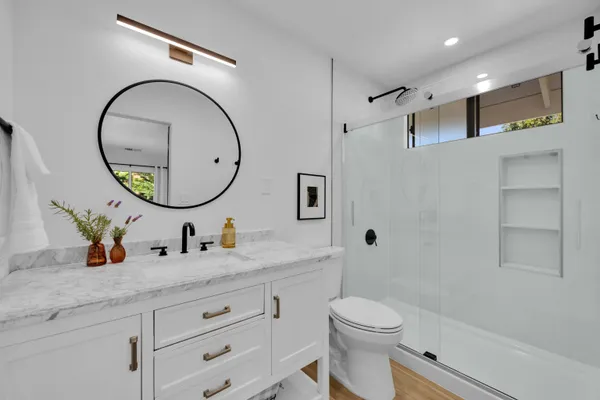 a bathroom with a granite countertop toilet sink and mirror