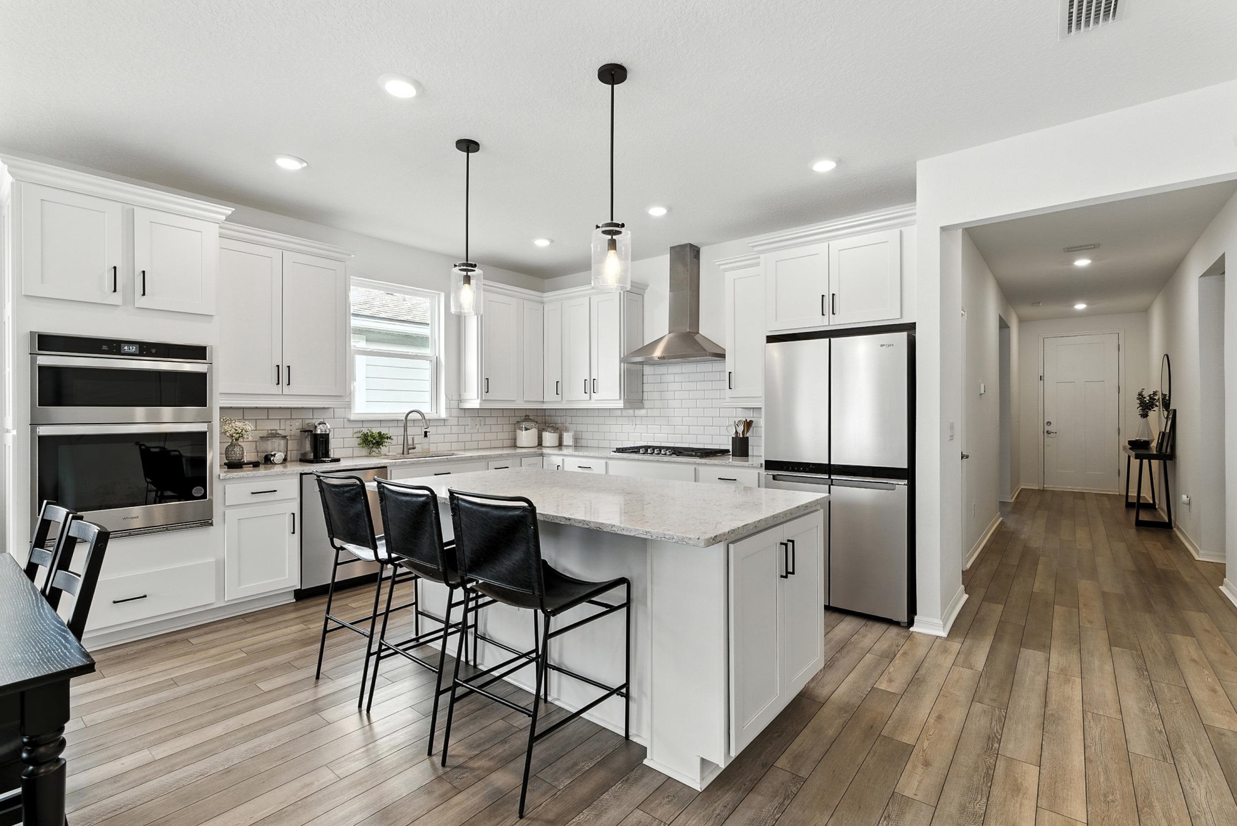 196 Red Barn Rd Street St. Augustine, FL 32092 - Photo 13 of 53 a kitchen with stainless steel appliances granite countertop a refrigerator a stove a oven a sink dishwasher and a dining table with wooden floor