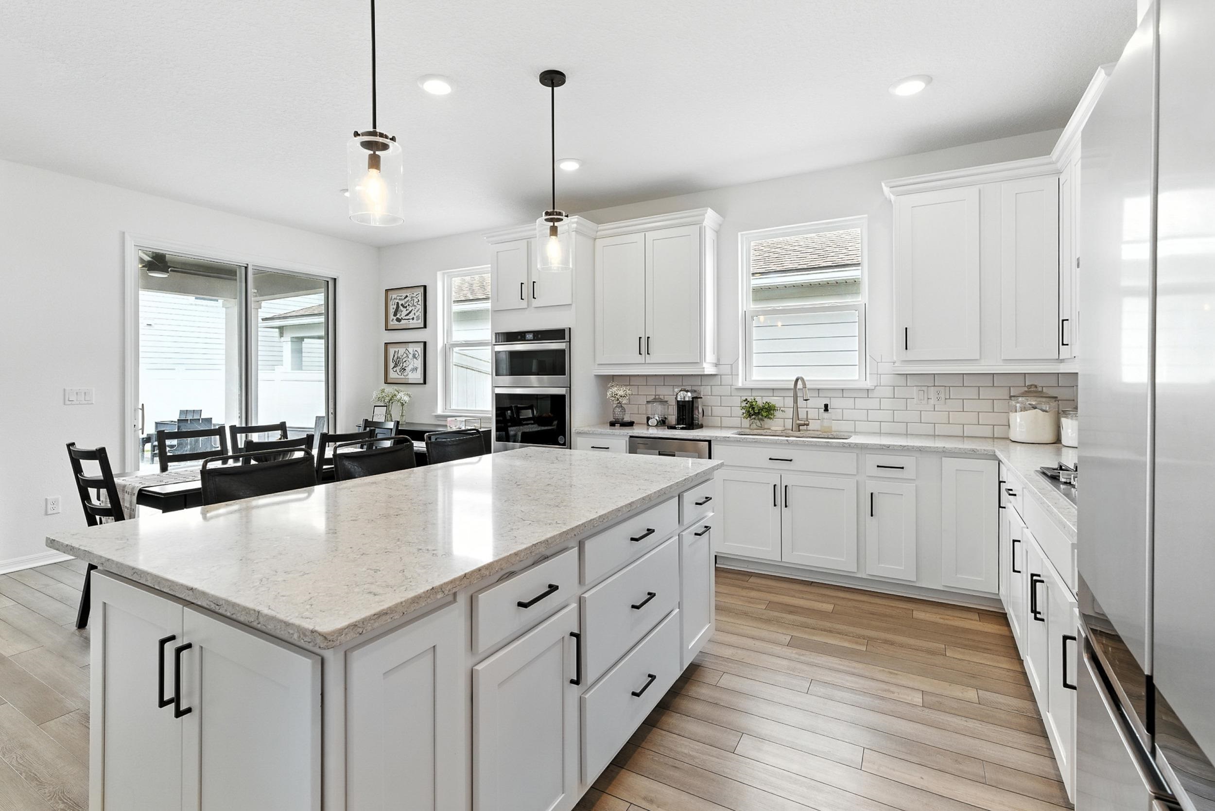 196 Red Barn Rd Street St. Augustine, FL 32092 - Photo 10 of 53 a kitchen with kitchen island granite countertop a white cabinets and wooden floor
