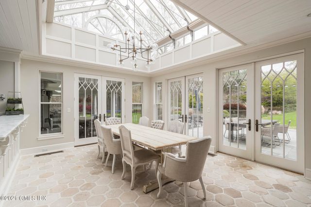 a view of a dining room with furniture large windows and wooden floor