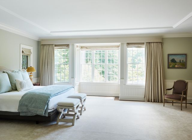 a bedroom with a bed and a large window