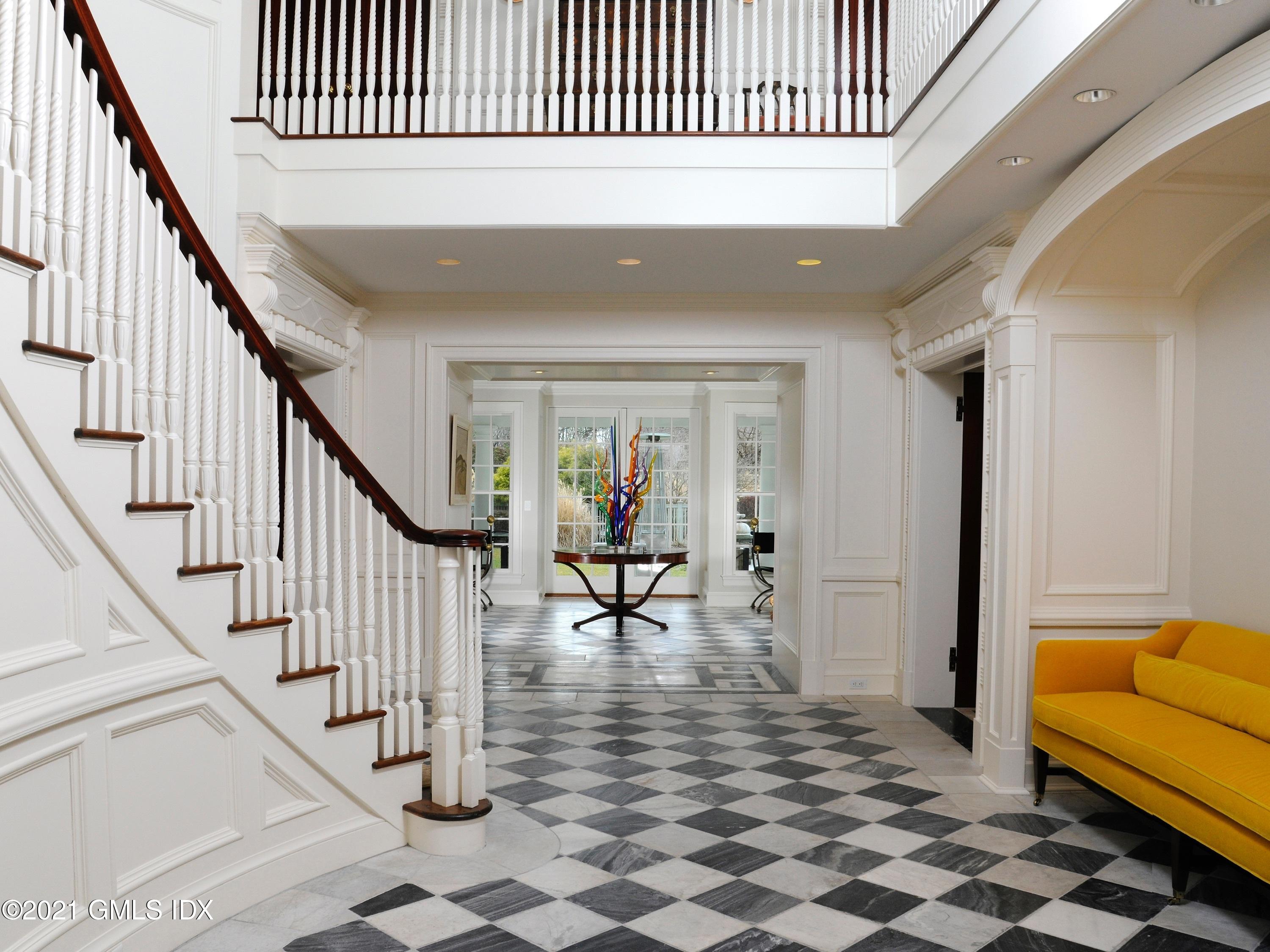 74 Upper Cross Road Greenwich, CT 06831 - Photo 7 of 40 a view of a hallway with wooden floor and a dining table