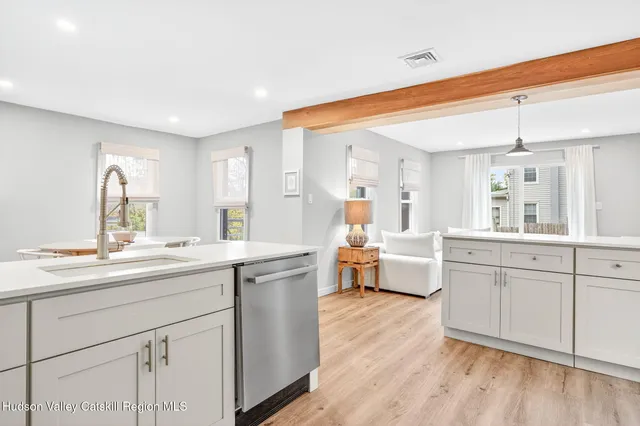 a large white kitchen with cabinets a sink and appliances