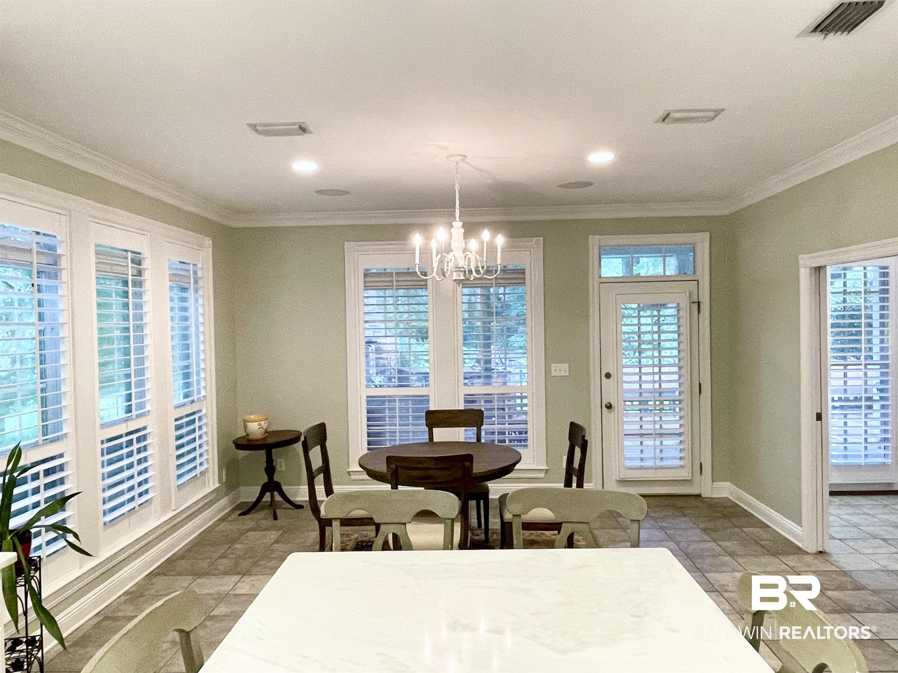 202 Potters Mills Road Daphne, AL 36526 - Photo 10 of 29 Tiled dining space featuring an inviting chandelier, crown molding, and plenty of natural light