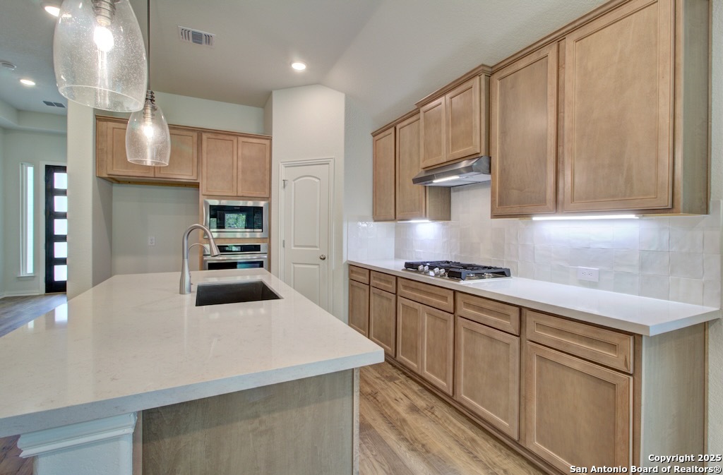 11910 Lofted Bloom Schertz, TX 78154 - Photo 12 of 26 a kitchen with stainless steel appliances granite countertop a sink stove and refrigerator