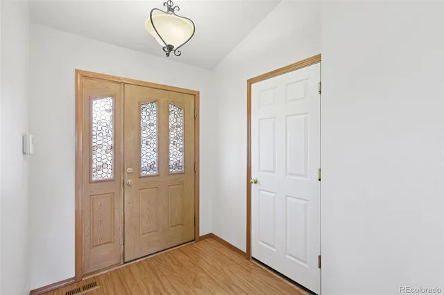 a view of a room with wooden floor and entryway