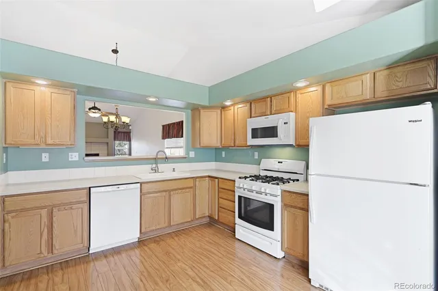 a kitchen with stainless steel appliances granite countertop a stove top oven a sink and white cabinets