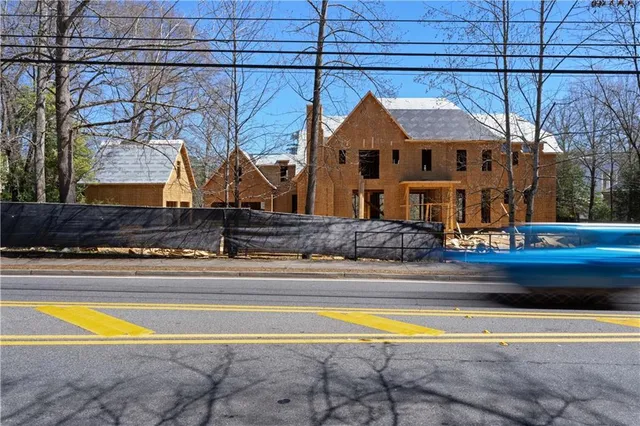 a front view of a house with snow on road