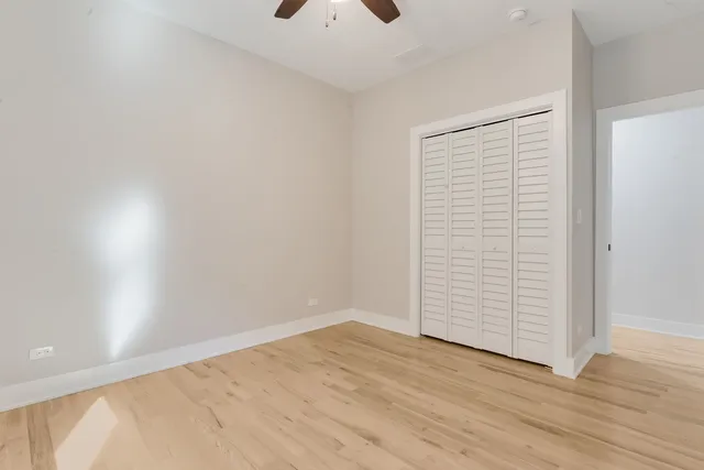 an empty room with wooden floor and closet