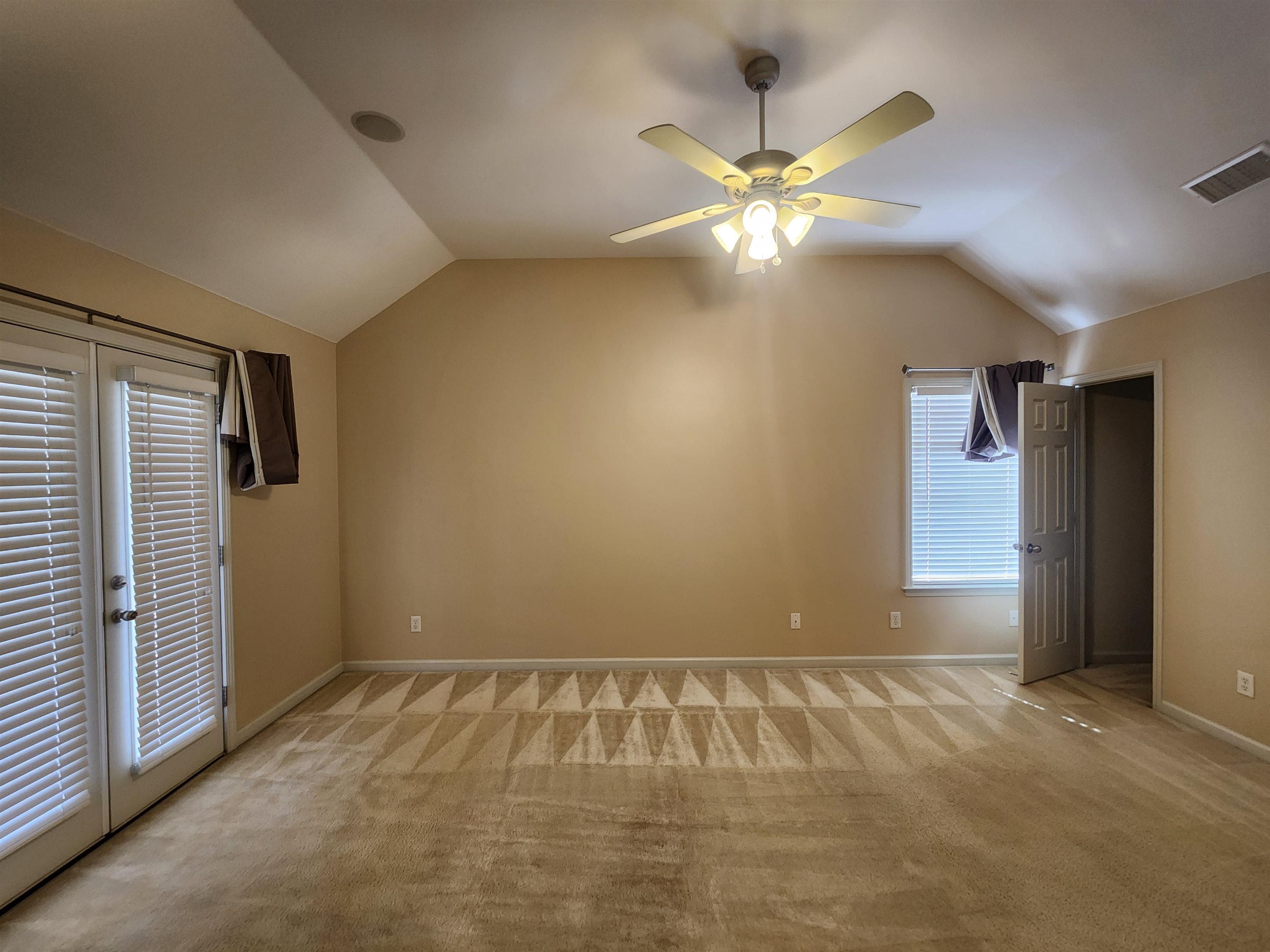 1459 Down River Drive Memphis, TN 38103 - Photo 13 of 27 Additional living space with ceiling fan, visible vents, vaulted ceiling, and light carpet