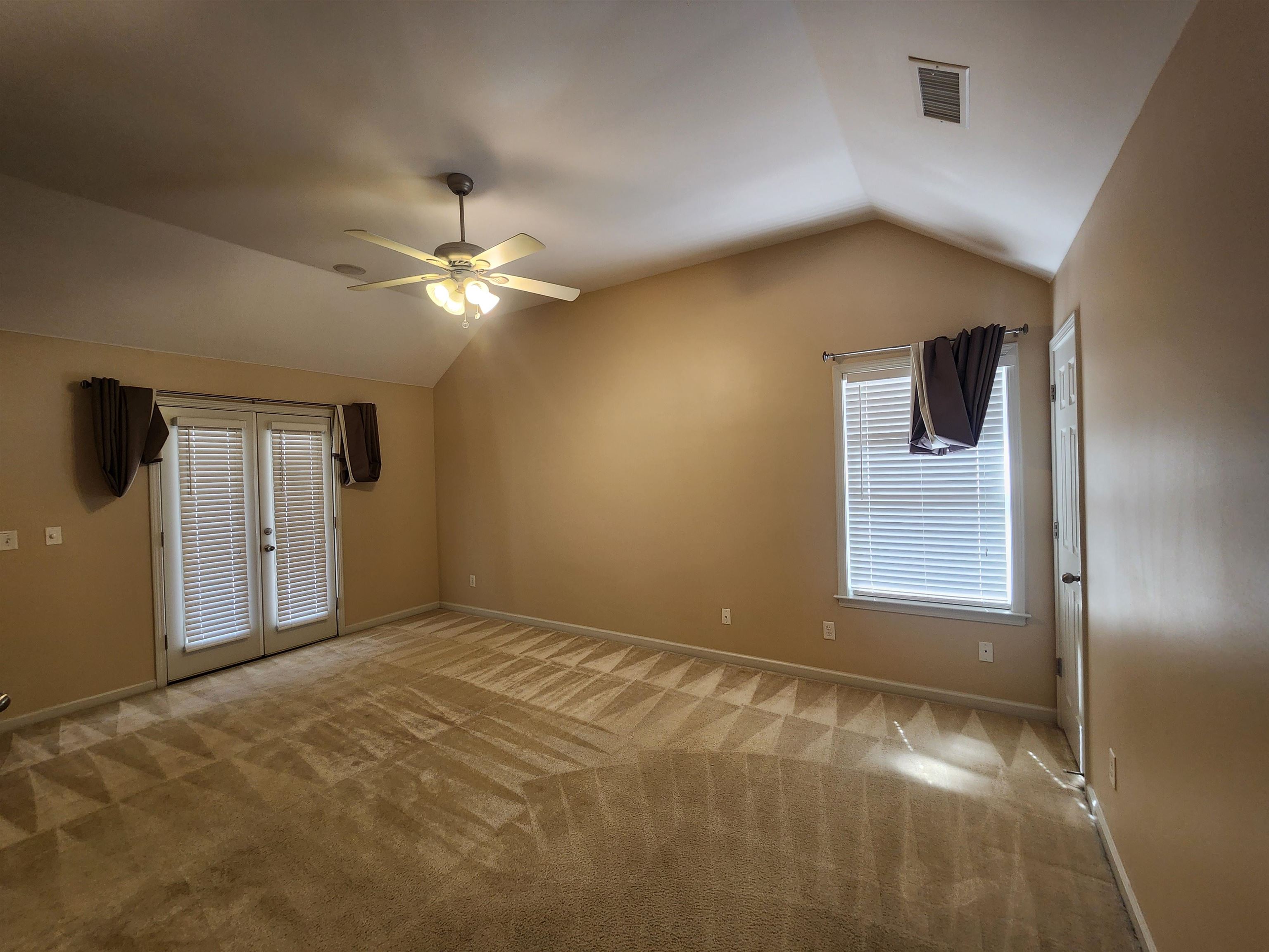 1459 Down River Drive Memphis, TN 38103 - Photo 14 of 27 Empty room with carpet flooring, visible vents, vaulted ceiling, a ceiling fan, and french doors