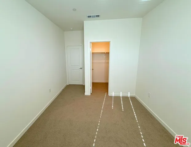 a view of a room with wooden floor and a ceiling fan