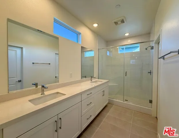 a bathroom with a double vanity sink mirror double and shower