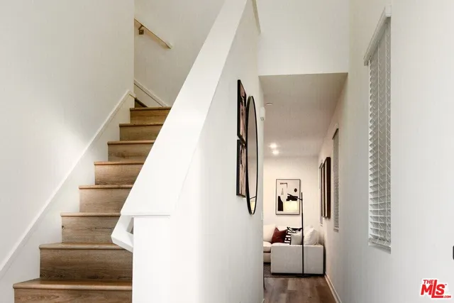 a view of staircase with white walls and railing