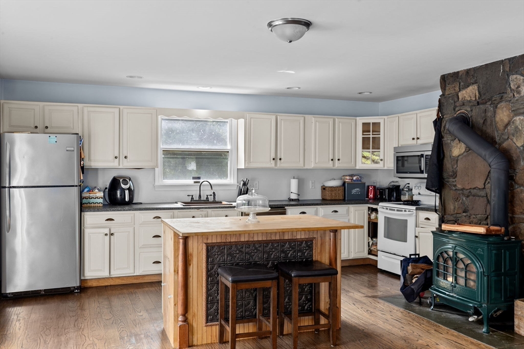 518 County Road Wareham, MA 02576 - Photo 7 of 32 a kitchen with a refrigerator a stove a sink dishwasher and a dining table with wooden floor