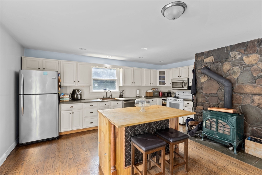 518 County Road Wareham, MA 02576 - Photo 9 of 32 a large kitchen with stainless steel appliances granite countertop a stove a refrigerator a kitchen island a table and chairs in it
