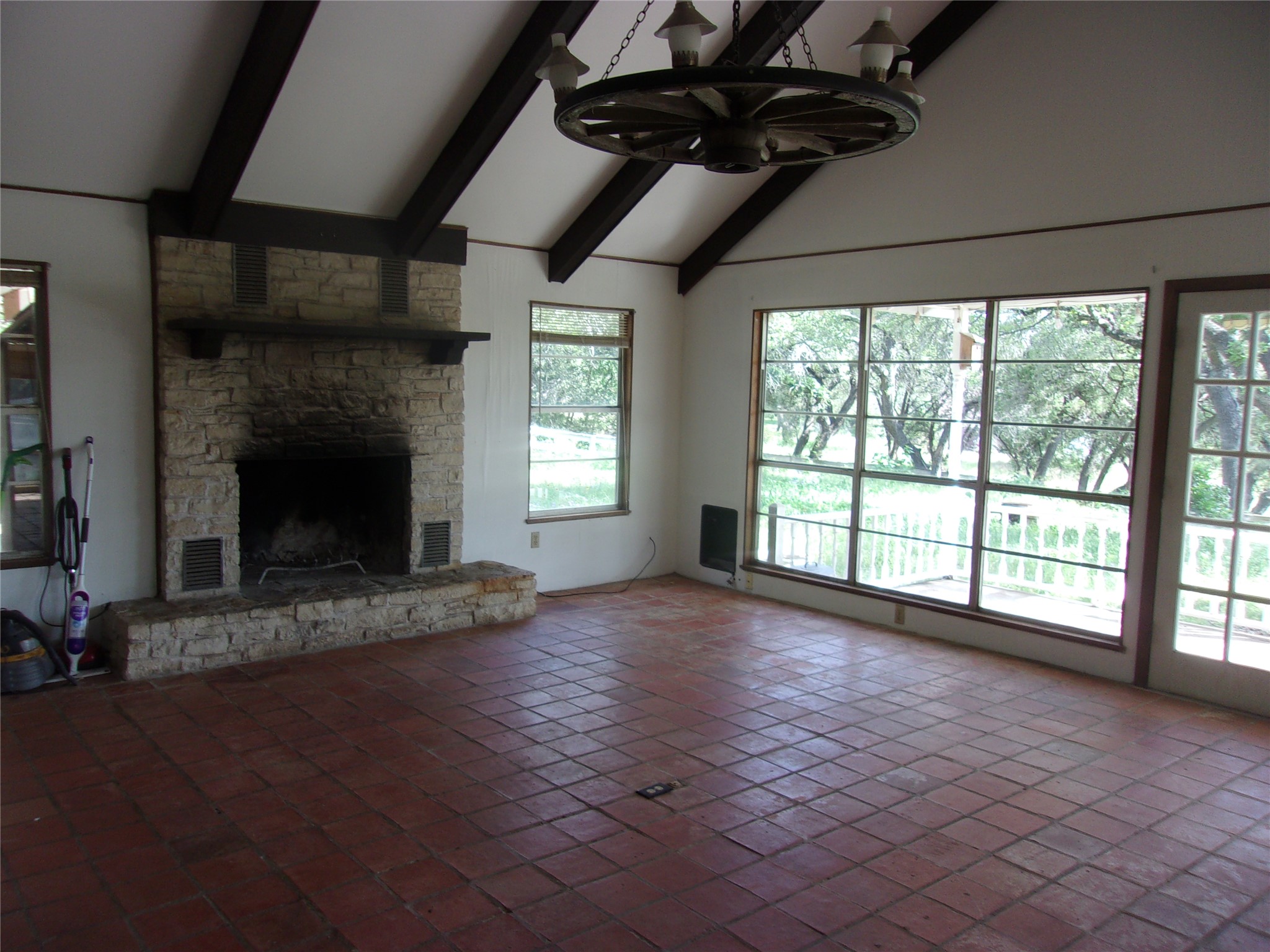 702 Cottonwood Creek Road Dripping Springs, TX 78620 - Photo 22 of 31 Spacious interior featuring exposed beam vaulted ceilings and a stone-faced fireplace with a mantel