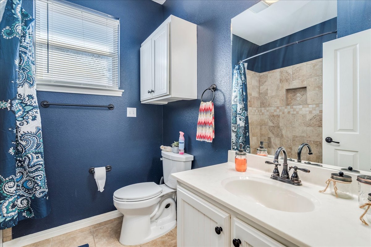 11 Rhapsody Lane Wimberley, TX 78676 - Photo 22 of 35 a bathroom with a sink a toilet and a mirror