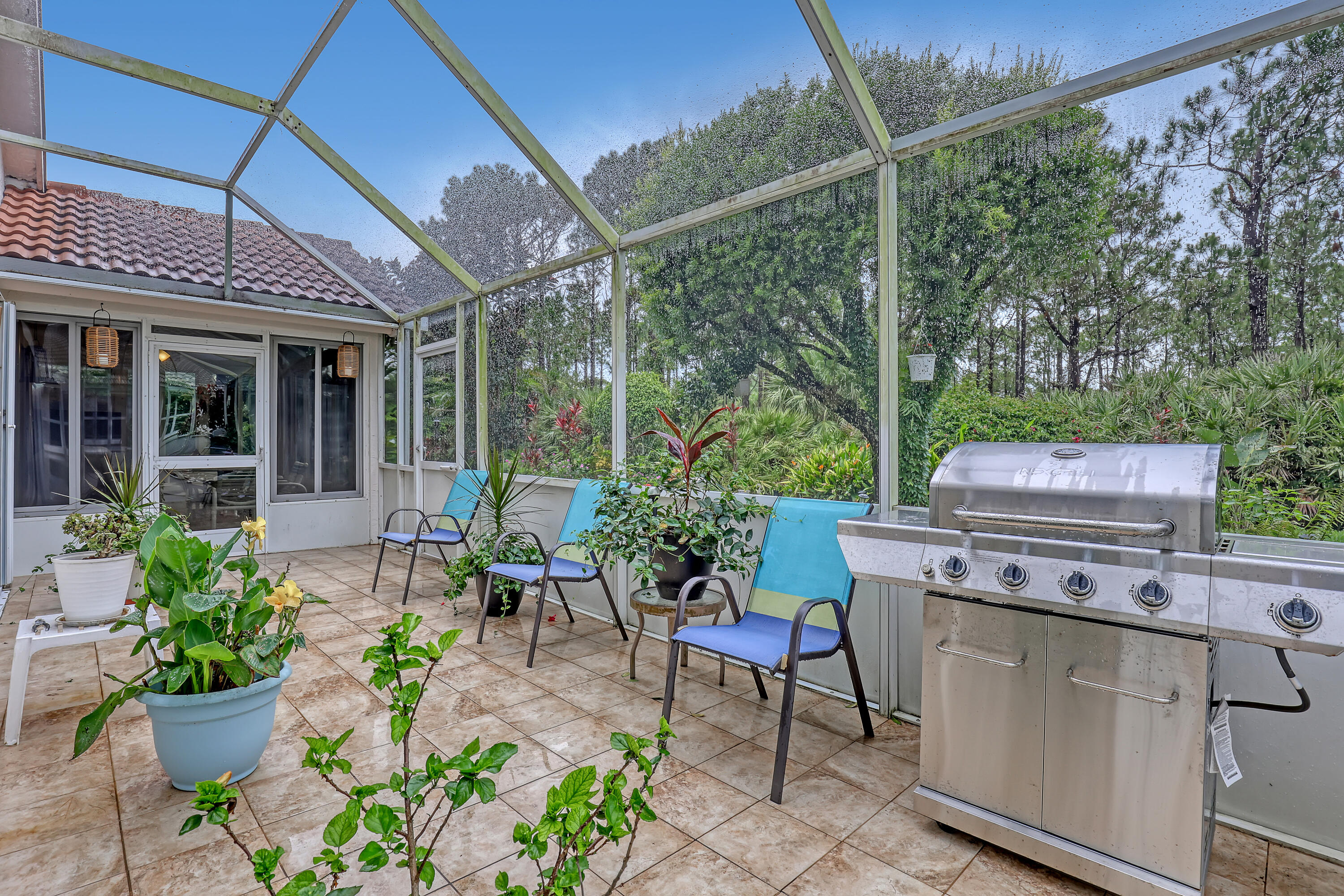 6995 Southeast Cutler Trail Stuart, FL 34997 - Photo 32 of 41 a view of a patio with table and chairs potted plants and large tree