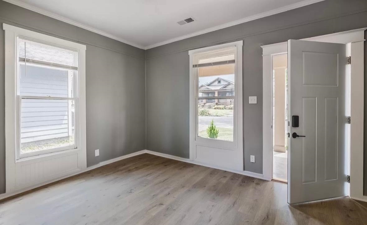 1033 Bruce Street Memphis, TN 38104 - Photo 3 of 9 a view of an empty room with wooden floor and a window