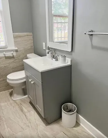 a bathroom with a sink toilet and a mirror
