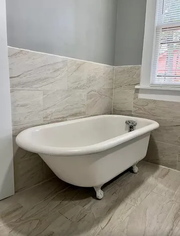a bathroom with a bathtub and window