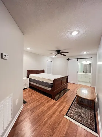 a bedroom with a bed and wooden floor