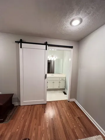 an empty room with wooden floor and mirror