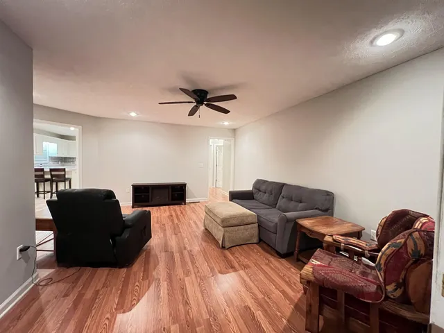 a living room with furniture and a wooden floor
