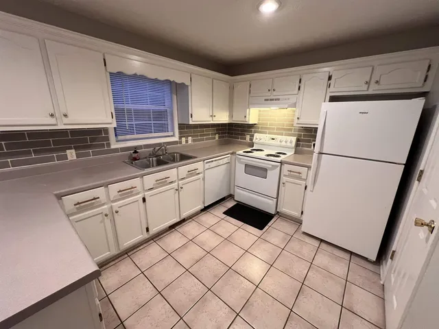 a kitchen with white cabinets sink and white appliances